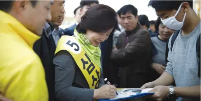  ?? (Kim Hong-Ji/Reuters) ?? SIM SANG-JUNG, the South Korean presidenti­al candidate of the Justice Party, signs an autograph during her election campaign rally in Seoul on Monday.