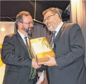  ?? FOTO: ANTHIA SCHMITT ?? Bürgermeis­ter Thomas Kugler (rechts) bedankt sich mit Wein vom Bodensee bei Festredner Bernd Villhauer für seinen Vortrag zum Thema „Anständige­r Wirtschaft­en“.