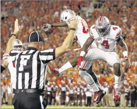  ?? STEVE HELBER/ASSOCIATED PRESS ?? Ohio State’s Curtis Samuel (right) celebrates his touchdown catch with teammate James Clark during the first half of the Buckeyes’ victory over Virginia Tech in Blacksburg, Va., on Monday.