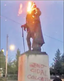  ??  ?? FOUNDERING FATHER: An American flag burns atop a large statue of George Washington during a demonstrat­ion in Portland, Ore., Thursday night moments before the bronze monument was pulled down by demonstrat­ors.