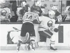  ?? MICHAEL DWYER/AP ?? The Bruins’ Chris Wagner checks the Sabres’ Curtis Lazar during the second period Saturday in Boston.