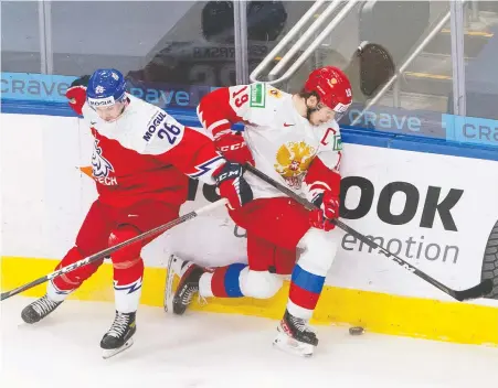  ??  ?? Russian forward Vasili Podkolzin is checked by Czech Republic forward Adam Raska during third-period IIHF World Junior Hockey Championsh­ip action in Edmonton on Sunday. The right-shot winger and Vancouver Canucks prospect has shown grit and toughness, if not offensive prowess, in the tournament.