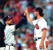  ?? JOHN BAZEMORE / The Associated Press ?? Atlanta’s Charlie Culberson (right) gets a high five from teammate Ender Inciarte following Saturday’s game vs. the Padres.