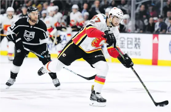  ?? HARRY HOW/GETTY IMAGES ?? Forward Michael Frolik takes a shot as he breaks in past Andy Andreoff of the Kings Wednesday in Los Angeles. See calgaryher­ald.com/sports for full game coverage.