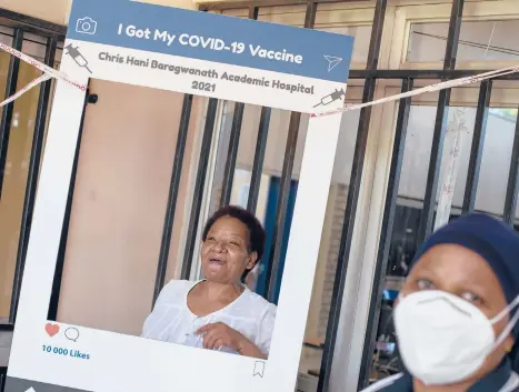  ?? THEMBA HADEBE/AP ?? Maggie Sedidi, left, rejoices after receiving a COVID-19 shot from a staffer March 5 in Soweto, South Africa. She is optimistic: “By next year, or maybe the year after, I really do hope that people will be able to begin returning to normal life.”