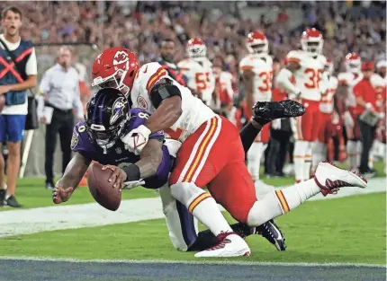  ?? JULIO CORTEZ/AP ?? Ravens quarterbac­k Lamar Jackson dives for a touchdown against Chiefs defensive end Michael Danna on Sunday in Baltimore. The Chiefs are giving up nearly 33 points per game through two games.