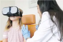  ??  ?? A child wearing virtual-reality glasses gets an entertaini­ng distractio­n as she receives a flu shot. To help those with a needle-aversion, a national network of pharmacies is offering videos that can be accessed via cellphones and viewed through goggles provided by the stores.