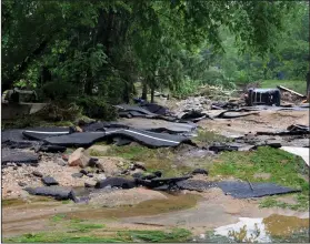  ?? AP Photo/David McFadden ?? Destroyed Roads: Destroyed chunks of roadway rest after being washed into a riverbed just off Main Street in flood-ravaged Ellicott City, Md., Monday. Sunday's destructiv­e flooding left the former mill town heartbroke­n as it had bounded back from...