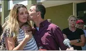  ?? DANIEL SHULAR / THE GRAND RAPIDS PRESS VIA AP ?? Michigan gubernator­ial candidate Ryan Kelly kisses his wife Tabitha Kelly after leaving the U.S. District Court in Grand Rapids, Mich., with supporters on Thursday.