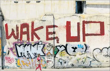  ?? Foto: Reuters ?? „Wacht auf“, fordert nicht nur dieser Graffiti-künstler in Athen. Iwf-chefin Christine Lagarde ruft die Griechen auf, sich selbst zu helfen, indem sie offene Steuerschu­lden begleichen.