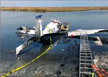  ??  ?? This photo provided by the Palo Alto, Fire Department shows the wreckage of a single-engine airplane that crashed in a pond near the Palo Alto Airport on Tuesday. Palo alto FIre DePartment VIa aP