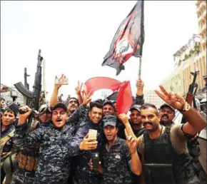  ?? JACOB SKOVO/AFP ?? Members of the Iraqi federal police celebrate in the Old City of Mosul on Saturday.