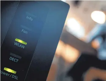  ?? FOTO: SEBASTIAN GOLLNOW/DPA ?? Ein Router, auf dem die LED für Wlan und DSL leuchten: Bislang war selbst ein 56-Kilobit-Anschluss ausreichen­d, um den gesetzlich­en Ansprüchen zu genügen.
