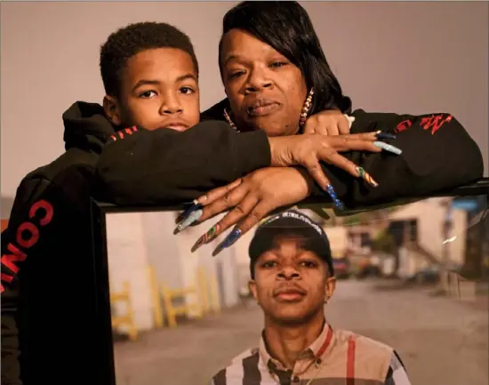  ?? Steve Mellon/Post-Gazette ?? Earlene Clancy, of Mount Washington, with son Imontae, 9, and a picture of her 17-year-old son, Izeyah, who was gunned down outside an Allentown convenienc­e store in May. “The pain is unbearable. It just tears the family apart,” she said.