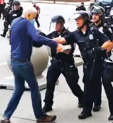  ??  ?? ...but one of the officers in Buffalo, New York, pushes him away with his baton