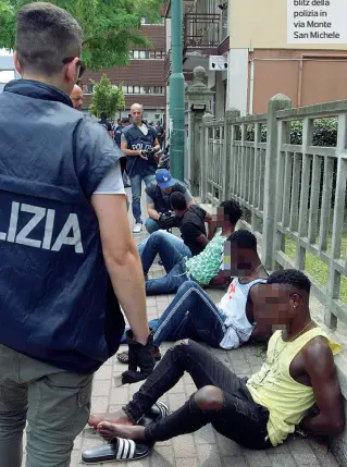  ??  ?? Per strada Alcuni degli stranieri che sono stati fermati martedì durante il blitz della polizia in via Monte San Michele