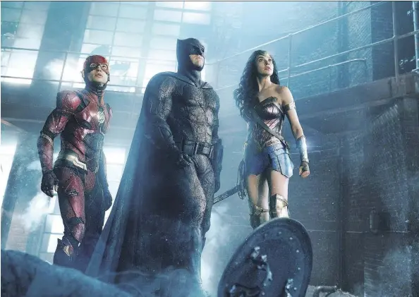  ?? WARNER BROS. ?? Ezra Miller, left, as The Flash, Ben Affleck as Batman and Gal Gadot as Wonder Woman star in Justice League, which opens on Friday. The movie aims to capitalize on Wonder Woman’s success in advance of a series of new DC movies planned for release next...