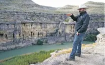  ?? ERIK VERDUZCO/THE ASSOCIATED PRESS ?? Terrell County Sheriff Thaddeus Cleveland points out a crossing point on the Rio Grande on Thursday in Terrell County, Texas.