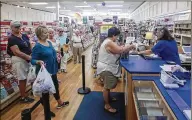  ?? PHOTOS BY BRUCE R. BENNETT / THE PALM BEACH POST ?? Donna Storms (right) helps Michele Fair, of Boynton Beach, with her packages Monday at Michele’s Hallmark in Boynton Beach.