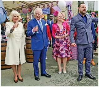  ?? ?? Roll out the barrel: Camilla and Charles toast the Queen with cast members Kellie Bright and Danny Dyer after filming their cameo