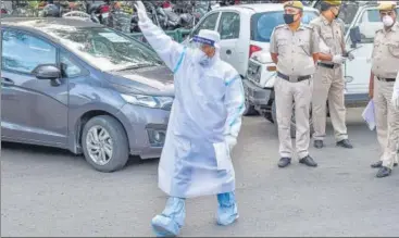  ?? PTI ?? A medic, donning personal protective equipment, in action after Nizamuddin was cordoned off by the police. n