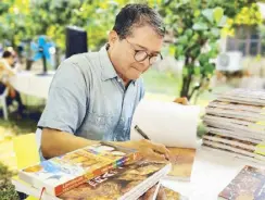  ?? ?? Chef Claude Tayag signs copies of his new book, The Ultimate Filipino Adobo: Stories through the Ages.
