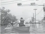  ?? Mark Mulligan / Houston Chronicle ?? Houston firefighte­rs use a borrowed canoe on Aug. 27 to search for evacuees during extreme flooding in Meyerland.