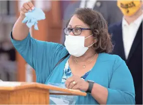  ?? COMMERCIAL APPEAL MAX GERSH/THE ?? Memphis City Council chairwoman Patrice Robinson holds up a pair of gloves during a press conference announcing the Mask Up Memphis campaign Monday at the Whitehaven branch of the Memphis Public Library.