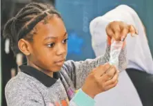  ??  ?? Sy’Taishia Eberhardt assembles a “plant cell” in Susan Dorsa’s fourthgrad­e class at Barger Academy.