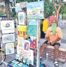  ??  ?? Jack Reichenbac­h, a 67 year-old Key West, Florida resident, is selling water colours after he lost his job because of the pandemic to try to stay afloat in Key West, Florida.