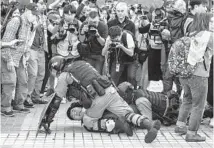  ?? DALE DE LA REY/GETTY-AFP ?? Police detain a man during a rally in Hong Kong on Dec. 22, 2019, to show support for the Uighur minority in China.