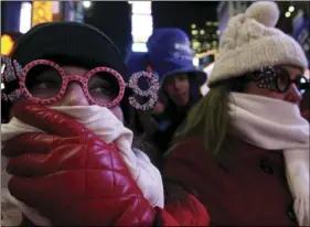  ??  ?? In this Dec. 31, 2008 file photo, Allison Smith of Jacksonvil­le, Fla, (left) tries to keep warm as she and others take part in the New Year’s Eve festivitie­s in New York’s Times Square. Brutal weather has iced plans for scores of events in the...