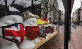  ?? Photograph: Guy Bell/Rex Shuttersto­ck ?? Face masks for sale on an empty London street during the third lockdown in March.