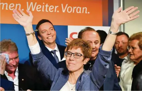  ?? Foto: Arne Dedert/dpa ?? Ministerpr­äsidentin Annegret Kramp-Karrenbaue­r (CDU, M.) jubelt auf der CDU-Wahlparty in Saarbrücke­n. Links ihr Mann Helmut.
