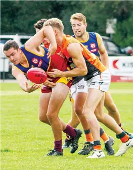  ?? ?? Warragul Industrial­s’ Thomas Commadeur fights to get a disposal out as he’s tackled.
Photograph by AMANDA EMARY.