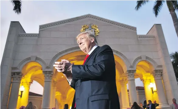  ?? — AFP/GETTY IMAGES ?? U.S. President Donald Trump watches the Palm Beach Central High School marching band perform as it greets him upon his arrival to watch the Super Bowl at Trump Internatio­nal Golf Club Palm Beach in West Palm Beach, Fla., on Sunday.