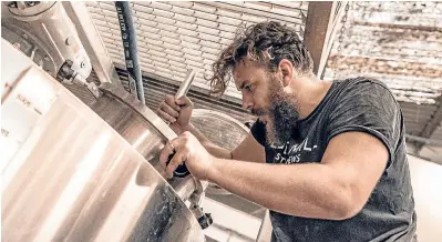  ??  ?? Eden Mill brewer and distiller Jasper Daly inspects the mash tun.