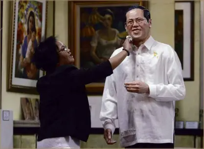  ?? RAFFY LERMA ?? NOT MADAME TUSSAUDS’ A resin statue of President Aquino gets a final dab from a caretaker of Gruppo Intramuros Cooperativ­e at Plaza San Luis Complex in Intramuros, Manila. The statue was made by artist Matthius Garcia.