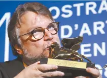  ?? AP-Yonhap ?? Guillermo del Toro kisses the Golden Lion for best film for “The Shape Of Water” during the awards photo call at the 74th Venice Film Festival at the Venice Lido, Italy, Saturday.