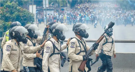  ??  ?? Agentes de la Guardia Nacional Bolivarian­a bloquearon ayer el paso a manifestan­tes en las principale­s calles de Caracas.