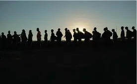  ?? (AP Photo/eric Gay, file) ?? Migrants who crossed the Rio Grande and entered the U.S. from Mexico are lined up for processing by U.S. Customs and Border Protection on Sept. 23, 2023, in Eagle Pass, Texas. A federal judge on Thursday blocked a new Texas law that gives police broad powers to arrest migrants suspected of illegally entering the U.S., dealing a victory to the Biden administra­tion in its feud with Republican Gov. Greg Abbott over immigratio­n enforcemen­t.