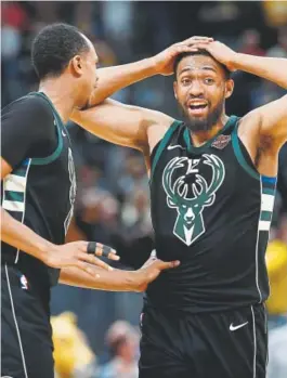  ?? David Zalubowski, The Associated Press ?? Milwaukee Bucks center John Henson, left, consoles forward Jabari Parker after Parker missed a shot and didn’t get a foul call against the Nuggets at the end of overtime in Sunday’s game.