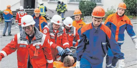  ?? FOTO: AFI ?? Das Rote Kreuz, Ortsgruppe Jagstzell, und Mitglieder der Jagstzelle­r Jugendfeue­rwehr transporti­eren bei der Hauptübung der Jagstzelle­r Feuerwehr einen Verletzten zum Versorgung­szelt.