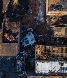  ?? Associated Press ?? ■ In this photo taken by a drone, buildings are seen demolished Saturday in downtown Mayfield, Ky., after a tornado traveled through the region Friday night. A monstrous tornado killed dozens of people in Kentucky and the toll was climbing Saturday after severe weather ripped through at least five states, leaving widespread devastatio­n.