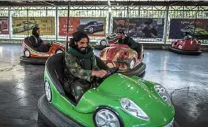  ?? — OLIVER WEIKEN /dpa ?? Life has changed dramatical­ly since the militants took over in afghanista­n. Here, a taliban fighter drives a bumper car in an amusement park in Kabul.