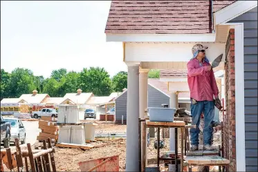  ?? NWA Democrat-Gazette/SPENCER TIREY ?? Mario Gueveca works May 18 on a house in the Mansions, a multifamil­y developmen­t off Mill Street in Springdale. The face of housing in Springdale is changing with different kinds of upscale developmen­ts.