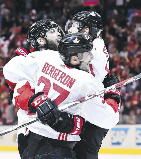  ?? FRANK GUNN / THE CANADIAN PRESS ?? Team Canada’s Patrice Bergeron celebrates his game-tying goal against Team Europe with teammates Brent Burns and Steven Stamkos during third period World Cup of Hockey action in Toronto on Thursday.