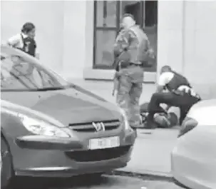  ?? — Gambar AFP ?? TUMPAS: Pegawai polis dan seorang askar melihat seorang lelaki di laluan pejalan kaki di pusat bandar Brussels, kelmarin. Lelaki tersebut telah menyerang seorang askar dengan bersenjata­kan pisau dan ditembak mati.