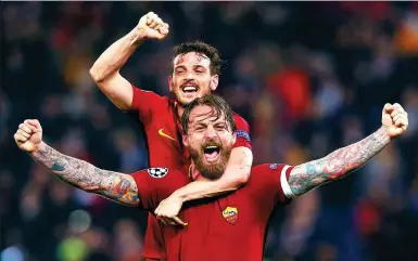  ?? ALESSANDRO BIANCHI / REUTERS ?? Roma's Daniele De Rossi (front) and Alessandro Florenzi celebrate beating Barcelona 3-0 at Rome’s Stadio Olimpico on Tuesday to reach the semifinals of the UEFA Champions League on the away-goals rule (4-4 aggregate score).