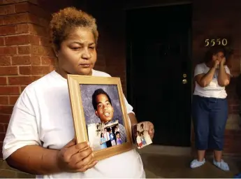  ?? John Leyba, Denver Post file ?? Helen Childs, mother of Paul Childs, holds a graduation photo of her son as she and her daughter Ashley stand on the front porch of their home in 2003.